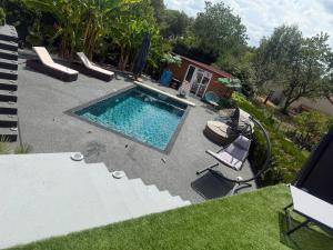an overhead view of a swimming pool with two lawn chairs at Maison cocooning , avec double jacuzzi et piscine in La Machine