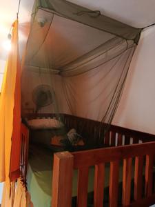 a bedroom with a bed with a canopy at Coco Mango Hostel in Hiriketiya