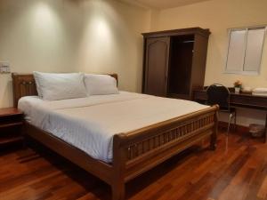 una cama en una habitación con un escritorio y una cama sidx sidx sidx en Prince Hotel Chiang Mai, en Chiang Mai