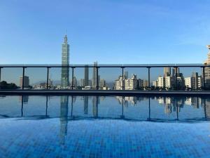 a swimming pool with a city skyline in the background at 琥珀皇后館 Amber Queen Chambers in Taipei