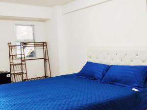 a bedroom with a bed with blue pillows and a ladder at Antareja Urban Town By Reccoma in Dukuh