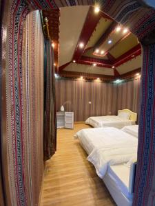 a bedroom with two beds and a ceiling with lights at Sun Horizon Chalet in Sa‘ab Banī Khamīs
