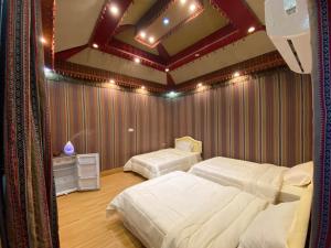 a bedroom with two beds in a room with red walls at Sun Horizon Chalet in Sa‘ab Banī Khamīs