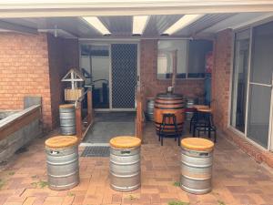 Taylors LakesにあるThe Welcome Innの樽とスツール、テーブルと椅子のあるパティオ