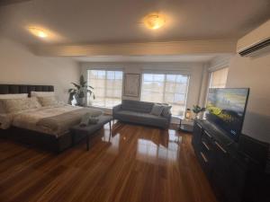 Taylors LakesにあるThe Welcome Innのベッド、ソファ、薄型テレビのある寝室 +2枚の写真