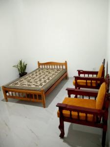 three wooden beds sitting in a room at Village Inn in Daulagala