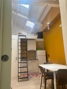 a room with a table and a kitchen with a ladder at Panta Rei 97 in Barletta