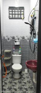 ein Badezimmer mit Toilette und rotem Waschbecken in der Unterkunft Bait al-Qamar in Kampong Wakaf Tengah + 7 Fotos