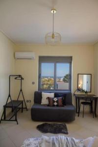 a living room with a blue couch and a window at Alba - Open Plan Apartment in Artemida