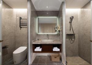 a bathroom with a sink and a toilet and a mirror at Nostalgia S Hotel Shanghai Railway Station & Suzhou Creek 时光漫步S酒店上海火车站苏州河店 Free fresh ground coffee,Free laundry service in Shanghai