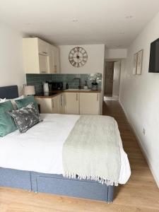 a large bed in a kitchen with a clock on the wall at The Little Fern in Oxford +17 photos