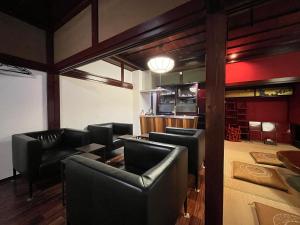 um restaurante com cadeiras de couro preto e um bar em 古民家宿 禅楽 em Shimminato mais 63 fotografias