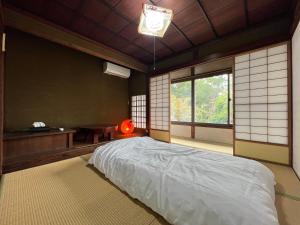 um quarto com uma cama, uma escrivaninha e uma janela em 古民家宿 禅楽 em Shimminato