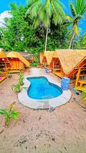 a resort with a small pool in front of some trees at Neena S House in Koh Phangan