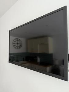 a mirror hanging on a wall with a clock at The Little Fern in Oxford