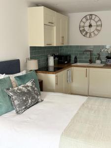 a kitchen with a bed and a clock on the wall at The Little Fern in Oxford