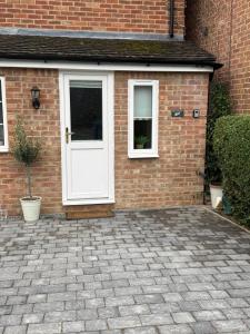 a brick house with a white door and windows at The Little Fern in Oxford