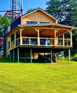 una grande casa in legno con un'auto parcheggiata di fronte di Cabana pe Deal a Remetea Chioarului