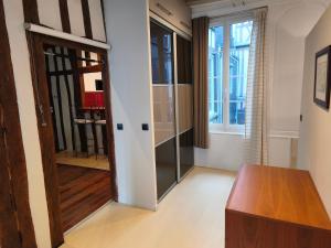 a living room with a door and a table at Le Vieux Palais Hypercentre Rouen, Place Vieux Marché - Linge & Ménage Inclus in Rouen