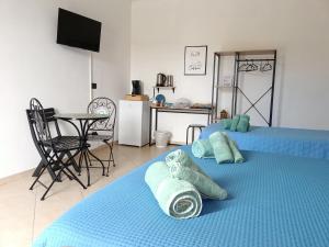 2 camas en una habitación con cocina y mesa en M'arriposu, en Realmonte