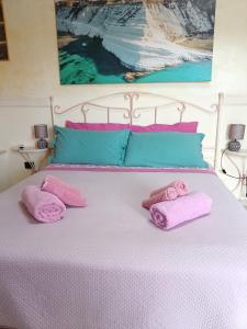 Una cama con toallas rosas encima. en M'arriposu, en Realmonte