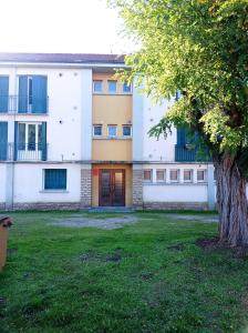 un bâtiment avec un arbre en face d'une cour dans l'établissement Grand appartement 3 chambres Wifi & Parking, à Gueugnon