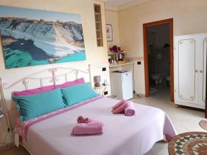 een slaapkamer met een bed met roze handdoeken bij M'arriposu in Realmonte