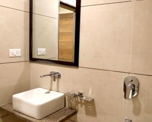 Un baño con un lavabo blanco y un espejo. en Adarsh Palace Hotel Near Bhopal Railway Station and Nadra Bus Stand Bhopal, en Bhopal