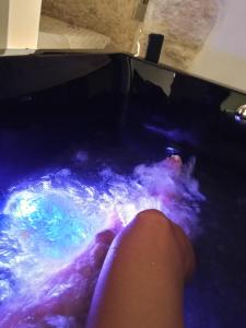 El pie de una persona en un jacuzzi con agua. en Suite GlassGreen, en Ostuni