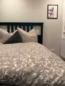 a bed with a gray and white blanket and pillows at Ferienwohnung SüntelLoft in Hameln +2 photos