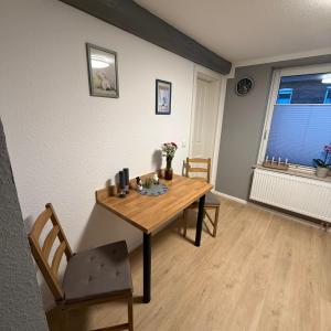 ein Esszimmer mit einem Holztisch und einem Fenster in der Unterkunft Ferienwohnung SüntelLoft in Hameln + 2 Fotos