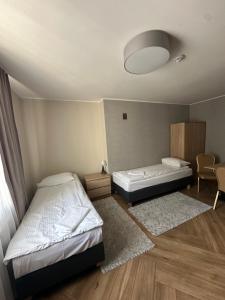 um quarto com duas camas, uma mesa e uma cadeira em GRACJA em Varsóvia mais 5 fotografias