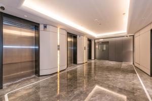 einen Flur mit Aufzügen in einem Gebäude in der Unterkunft Yasfield Hotel, Beijing Tuanjiehu Hujialou Subway Station Branch in Peking + 6 Fotos