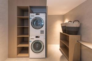 eine Waschküche mit Waschmaschine und Trockner in der Unterkunft Yasfield Hotel, Beijing Tuanjiehu Hujialou Subway Station Branch in Peking