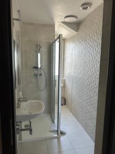 um banheiro com chuveiro e pia em GRACJA em Varsóvia