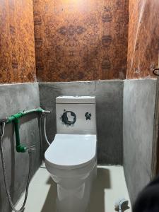 baño con aseo con pegatinas en Paldor Peak Guest House, en Thāngjet