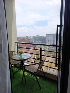 a table and chairs on a balcony with a view at Executive Studio in Kinoo in Rungiri