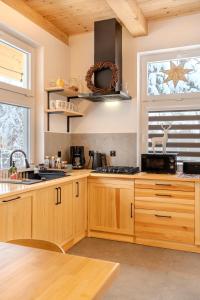 une cuisine avec des armoires en bois et une fenêtre dans l'établissement Domek w Sercu Ustrzyk, à Ustrzyki Dolne