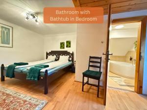 a bedroom with a bed and a chair in a room at Alpinlake Apartments - Grünau im Almtal in Grünau im Almtal +31 photos