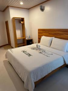 ein Schlafzimmer mit einem großen weißen Bett mit weißer Bettwäsche in der Unterkunft The Palm Retreat Maldives in Gaafaru