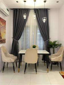 a dining room with a table and chairs and a window at The Roomist in Lekki