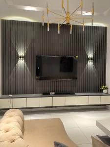 a living room with a large television on a wall at The Roomist in Lekki