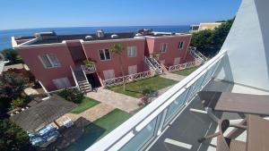 una casa rosa con l'oceano sullo sfondo di Apt. El Guirre Nº 3 a Valle Gran Rey