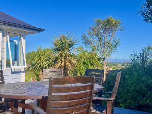 a table and chairs on a patio with a view at Top of Tyne - Peace, Comfort & Local Connection in Oamaru
