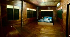 a room with a couch in a room with wooden walls at Teak house pai in Ban Na Toeng Nai