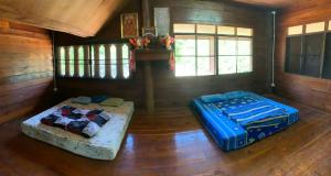 two beds in a room in a cabin at Teak house pai in Ban Na Toeng Nai