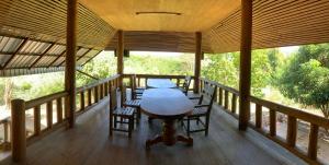 a porch with a table and chairs on it at Teak house pai in Ban Na Toeng Nai