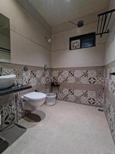 un baño con inodoro y lavabo en The Boho Peach Villa, en Mount Abu 38 fotos más