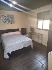 Un dormitorio con una cama, una mesa y un televisor. en Estudio la matilla, en Palos de la Frontera
