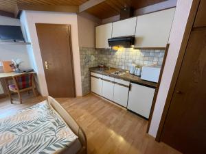 a small kitchen with white cabinets and a table at Appartement an der Steinach in Nagold